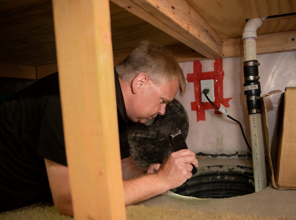 Home inspector inspecting sump pump
